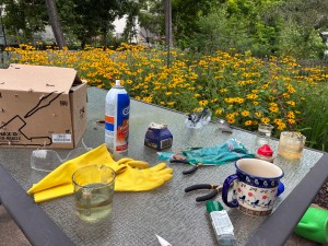 Tools, rubber gloves and junk on a glass patio table.